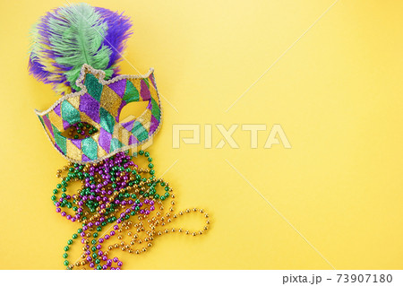 Mardi gras or carnival mask with beads on yellow background. Venetian mask. 73907180