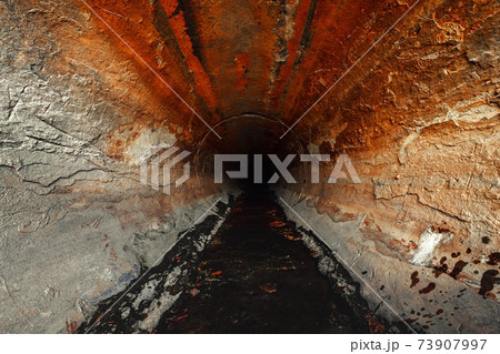 Large sewage tunnel with filth flowing out 73907997