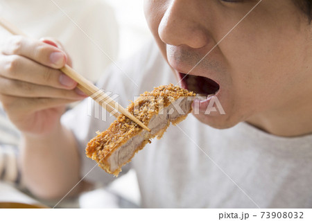 食べる　食欲　肉を食う若者 73908032