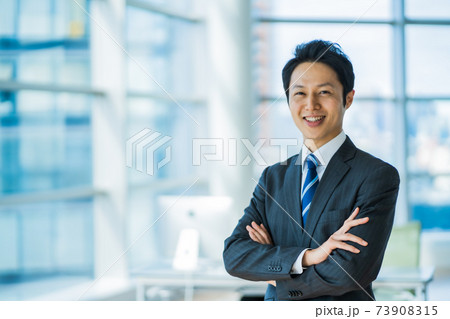 洗練されたオフィスで働くスーツ姿の30代男性の写真素材