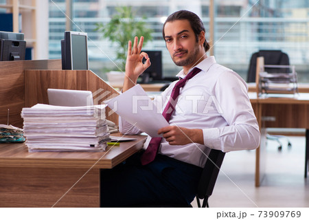 Young male employee and too many work in the office Young male employee and too many work in the office 73909769