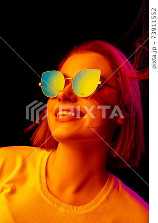 Caucasian woman's portrait isolated on black studio background in multicolored neon light Caucasian woman's portrait isolated on black studio background in multicolored neon light 73911552