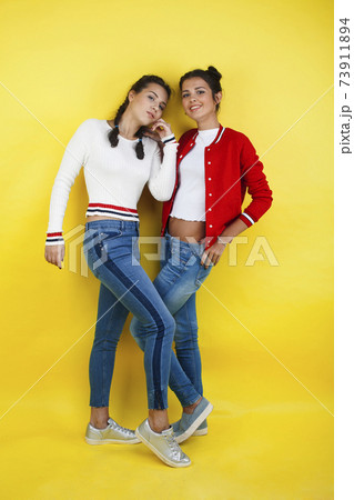lifestyle people concept: two pretty young school teenage girls having fun happy smiling on yellow background 73911894