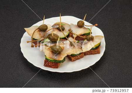 Herring fillet canape with caperberry Herring fillet canape with caperberry 73912957