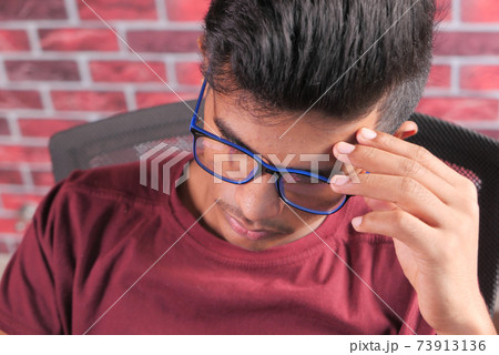 sad young man sits alone on a chair  73913136