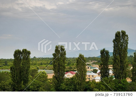 Houses at the foot of Caucasus Mountain range with peak snow background in Gebele, Gabala Azerbaijan  73913760