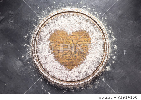 Wheat flour at wooden pizza or bread cutting board for homemade baking on table 73914160