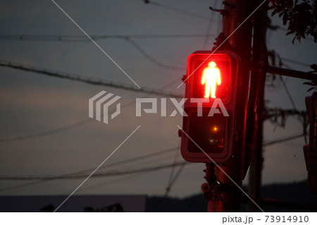 夕暮れの歩行者信号機の赤信号の風景の写真素材