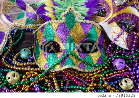 A group of Venetian and New Orlean Mardi gras mask with colorful beads on dark background 73915228