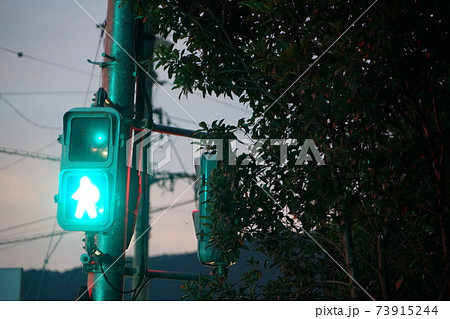 夕暮れの歩行者信号機の青信号の風景の写真素材