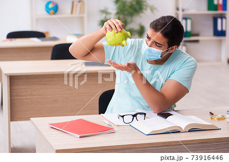Young man in expensive education concept during pandemic Young man in expensive education concept during pandemic 73916446