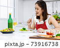 Happy Asian woman enjoy eating steak she make. Concept woman preparing meals at home. 73916738