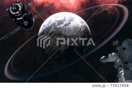 Planet Earth with rings. Astronaut out of focus. Space station blurred in motion. Solar system. 3D Render 73917608