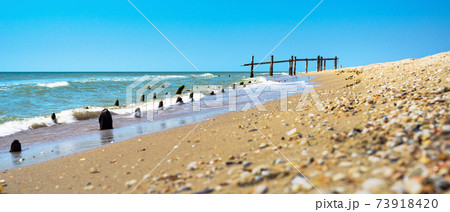 Ruined pier on shore of beautiful sea 73918420
