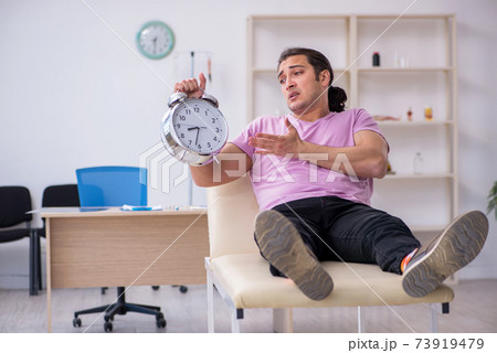 Young male patient waiting for doctor in time management concept 73919479