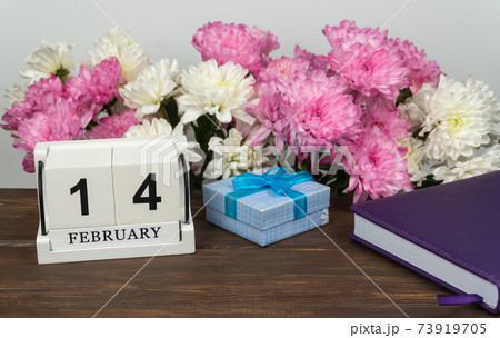 Desktop calendar with the date of February 14 and a bouquet of beautiful flowers. Delicate chrysanthemums 73919705
