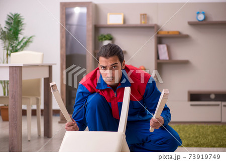 Young male contractor repairing chair indoors 73919749