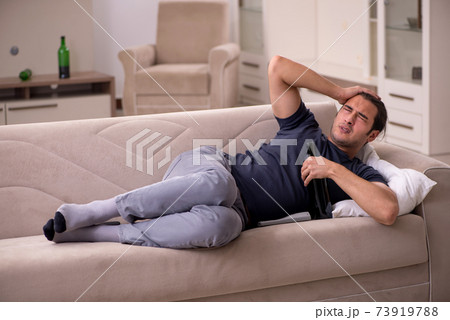 Young male alcoholic suffering at home 73919788