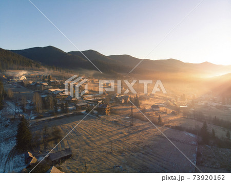 Mountain Village in the Morning. Aerial Shot of Majestic Sunrise in a Valley at Foggy Morning Mountains Landscape. Fir Tops and Cozy Houses in Carpathians, Tatariv, Ukraine, Europe 73920162