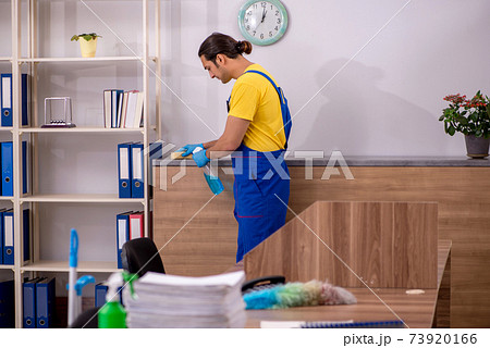 Young male contractor cleaning the office 73920166