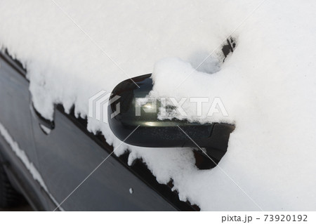 The mirror of the car is covered with snow. 73920192