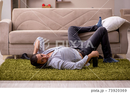 Young drunk man suffering at home Young drunk man suffering at home 73920369