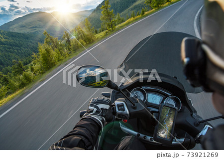 Motorcycle driver riding in Alpine route. 73921269