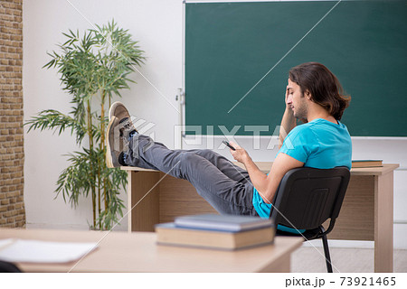 Young male student in front of green board Young male student in front of green board 73921465