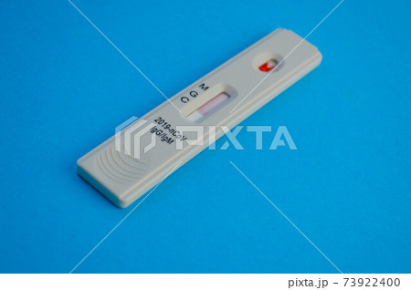 coronavirus test lies on a blue background. a drop of venous blood on the test strip. express diagnostics of coronavirus. test shows the patient has a coronavirus 73922400