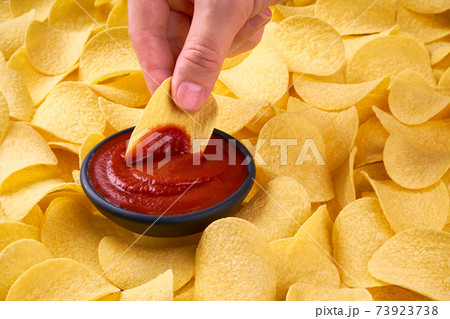 man holds potato chips in hands, closeup photo with selective focus. 73923738