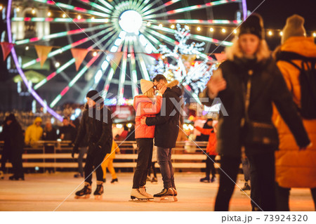 Ice skating together. Romantic winter vacation in ice arena. Young couple skating at ice rink. Best Christmas ever. Winter fun. Cute Valentine's Day. New Year with couple on skating. winter holidays 73924320