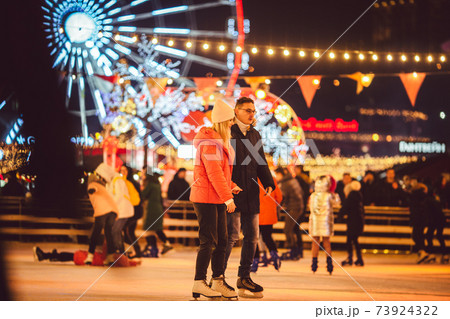 Ice skating together. Romantic winter vacation in ice arena. Young couple skating at ice rink. Best Christmas ever. Winter fun. Cute Valentine's Day. New Year with couple on skating. winter holidays 73924322