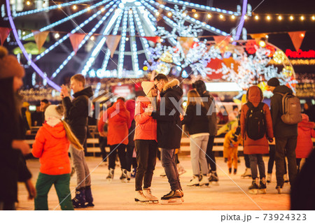 Ice skating together. Romantic winter vacation in ice arena. Young couple skating at ice rink. Best Christmas ever. Winter fun. Cute Valentine's Day. New Year with couple on skating. winter holidays 73924323