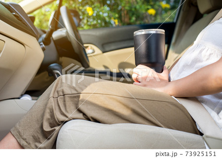 Hand woman holding reusable water bottle in car,Environmental friendly,Healthy green,Zero waste,Conscious lifestyle concept 73925151