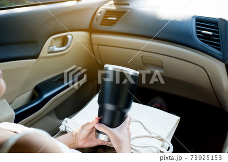 Hand woman holding reusable water bottle in car,Environmental friendly,Healthy green,Zero waste,Conscious lifestyle concept 73925153
