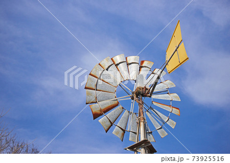 風の力で水を汲み上げる風車の写真素材