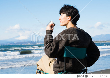 江ノ島の海を眺めながらコーヒを飲む男性 江ノ島の海を眺めながらコーヒを飲む男性 73927685