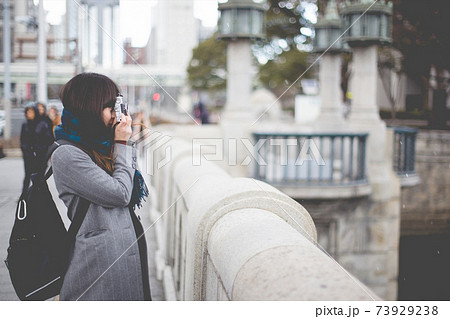 写真撮影　フィルムカメラを構えるマフラーを巻いた女性　横向き 73929238