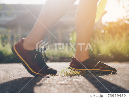 Woman wear running shoe on to walking and running on nature green background.Health exercise. Woman wear running shoe on to walking and running on nature green background.Health exercise. 73929480