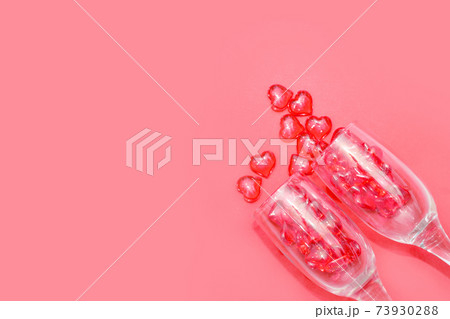 two glasses with hearts on a red background. the view from the top. red hearts spilled out of the glasses. isolated on a pink background. copy space 73930288