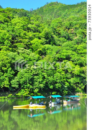 京都の町並み 嵐山 桂川 の観光遊覧船と新緑の山並みの写真素材