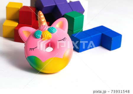 Children toys wooden colorful blocks and squash antistress toy donut unicorn on white Children toys wooden colorful blocks and squash antistress toy donut unicorn on white 73931548