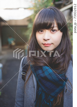 路地にて　マフラーを巻いたロングヘアの女性　アップ 73932012