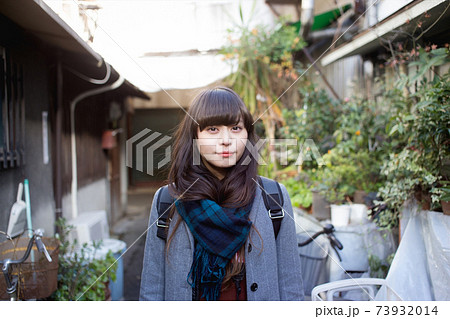 路地にて マフラーを巻いたロングヘアの女性の写真素材