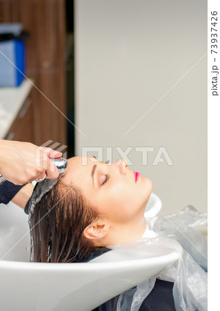 Hairdresser is rinsing the hair Hairdresser is rinsing the hair 73937426