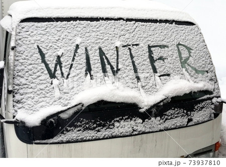 Winter, a car covered with snow. The inscription on the windshield 73937810