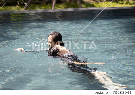Life guard woman holding sinking child swimming in water,female lifesaver helping girl in summer vacation,first aid for drowning tourist or asian mother rescuing unconscious daughter drowning in swimm 73938941