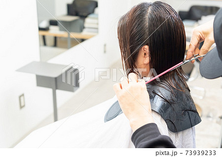 ヘアサロンで髪の毛をカットしてもらう若い女性 ヘアサロンで髪の毛をカットしてもらう若い女性 73939233