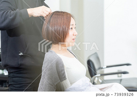 ヘアサロンで髪の毛をカットしてもらう若い女性 ヘアサロンで髪の毛をカットしてもらう若い女性 73939326