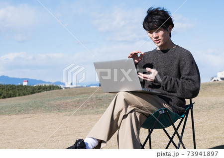 江ノ島の海でワーケーションの男性 73941897